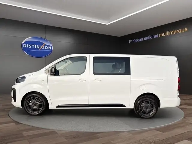 Vue de profil côté gauche du Citroën Jumpy blanc, fourgon utilitaire avec vitres teintées à l'arrière.