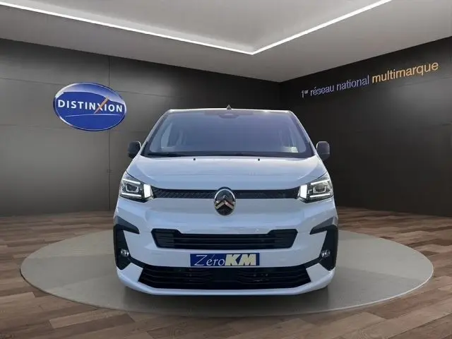 Vue frontale d'un Citroën Jumpy XL blanc 2026, avec logo distinctif et plaque "Zero KM" en showroom.