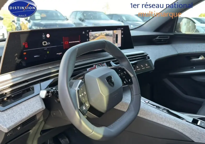 Vue intérieure du poste de conduite du Peugeot 5008 Hybrid 145 allure e-dcs6 avec volant cuir et tableau de bord numérique.