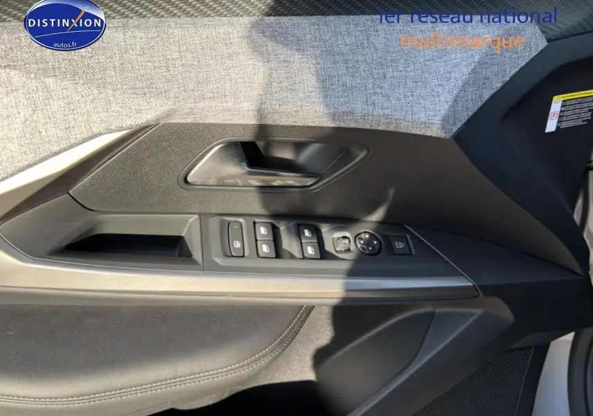 Vue intérieure côté gauche de la porte avant du Peugeot 5008 gris Artense avec commandes des vitres et rétroviseurs.