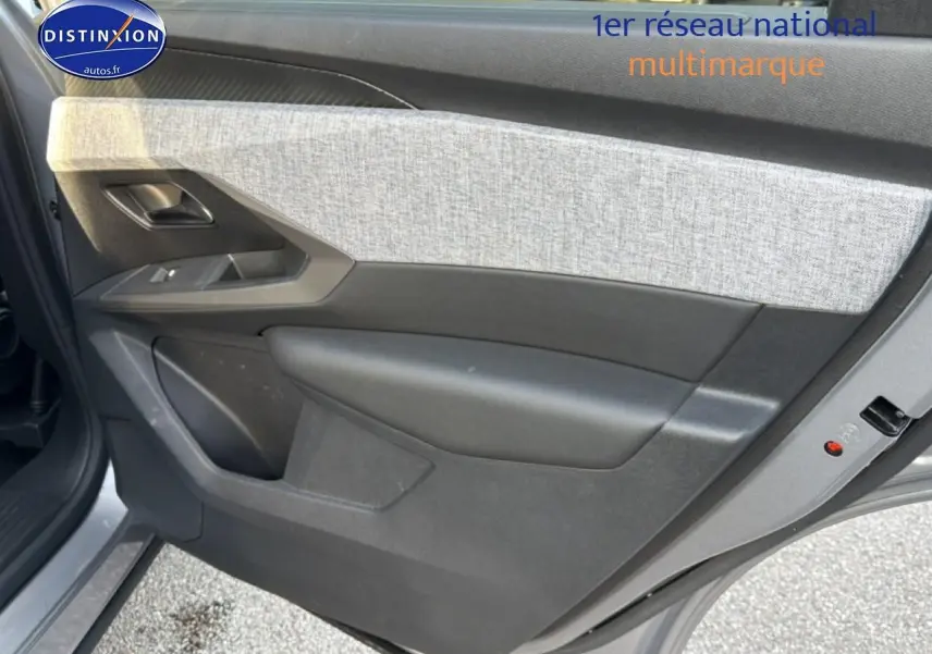 Vue rapprochée de la porte arrière gauche gris artense du Peugeot 5008 Hybrid 145 allure e-dcs6 avec tissu clair et plastique noir.