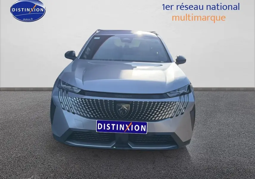 Vue frontale d’un Peugeot 5008 Hybrid 145 allure e-dcs6 gris artense avec calandre distinctive et phares LED fins.