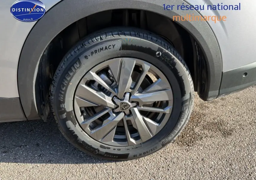 Gros plan sur la roue avant droite du Peugeot 5008 gris Artense avec jante alu et pneu Michelin.