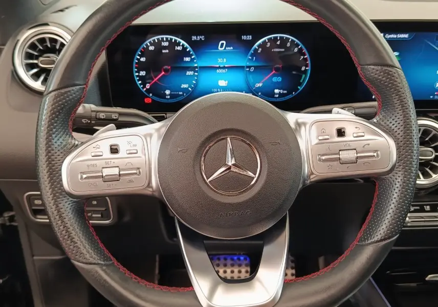 Vue rapprochée du volant cuir noir avec surpiqûres rouges et tableau de bord numérique du Mercedes GLA 250 e AMG Line 2021.