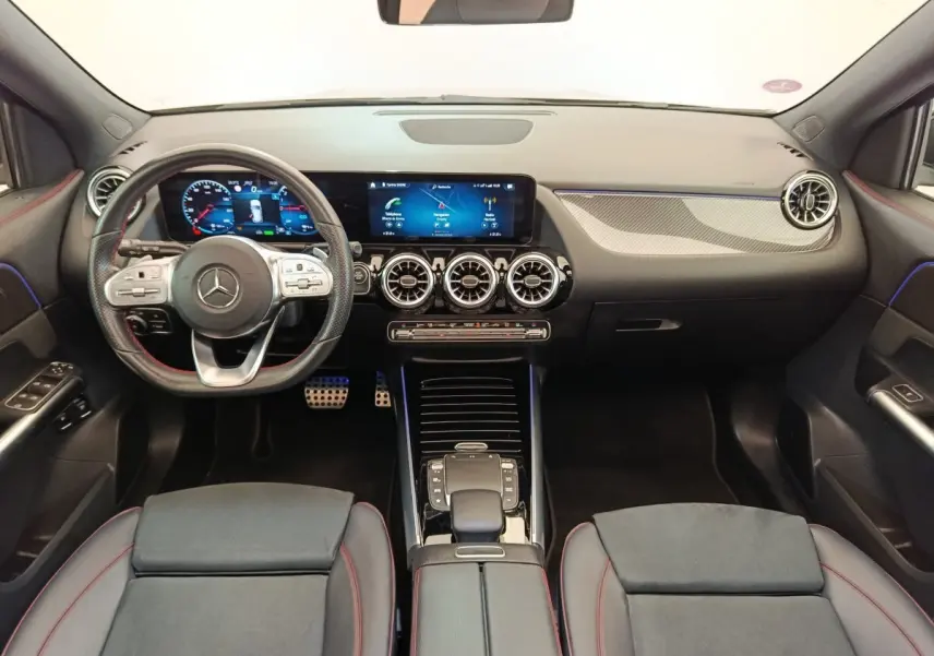 Vue intérieure avant du Mercedes GLA 250 e AMG Line 2021, tableau de bord noir avec écrans numériques et volant cuir.