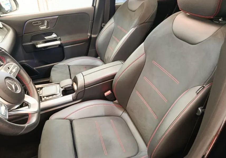 Vue intérieure rapprochée des sièges avant noirs avec surpiqûres rouges du Mercedes GLA 250 e AMG Line 2021.