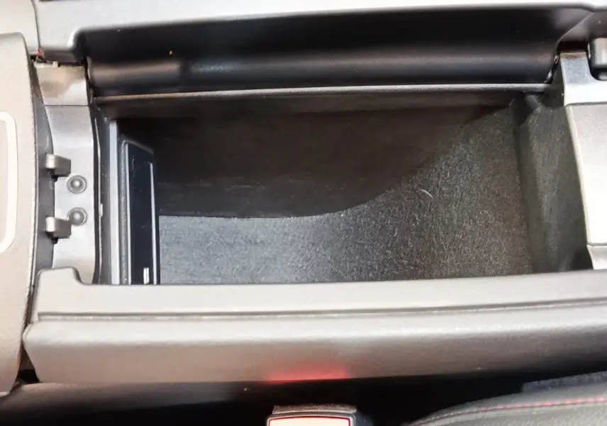 Vue rapprochée de la console centrale ouverte du Mercedes GLA 250 e AMG Line 2021, intérieur noir avec surpiqûres rouges.