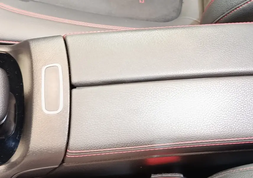 Détail de la console centrale en cuir noir avec surpiqûres rouges dans une Mercedes GLA 250 e AMG Line 2021.