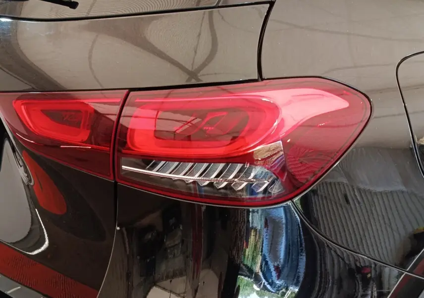 Gros plan sur le feu arrière droit rouge d’un Mercedes GLA 250 e AMG Line noir, vue arrière latérale.