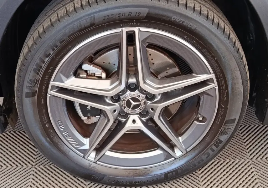 Gros plan sur la jante AMG étoile en alliage gris foncé du côté gauche d’un Mercedes GLA noir hybride rechargeable.
