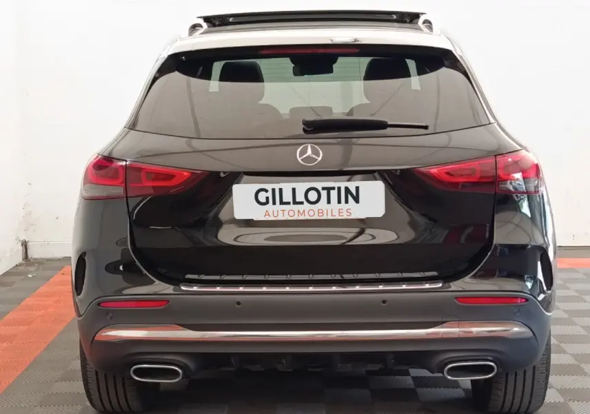 Vue arrière d'un Mercedes GLA 250 e AMG Line noir avec feux LED et double sortie d'échappement chromée.