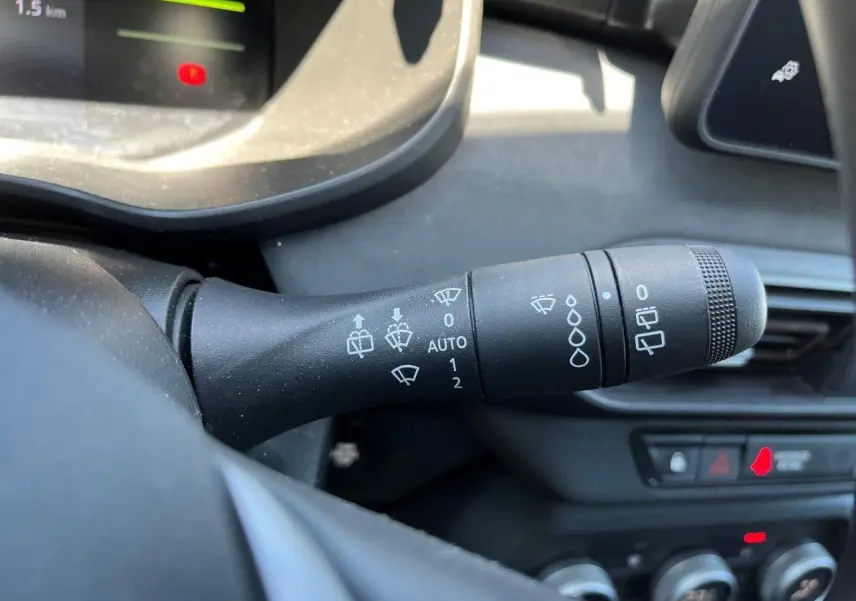 Gros plan sur la commande des essuie-glaces du tableau de bord du Dacia Jogger 1.6 Hybrid 2025, intérieur noir.