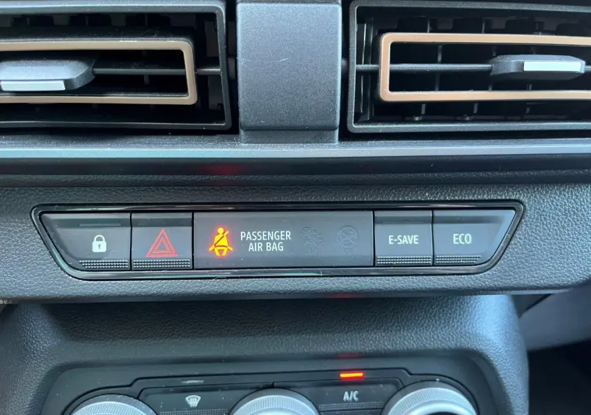 Gros plan sur la console centrale du Dacia Jogger 2025, montrant les boutons de sécurité et climatisation.