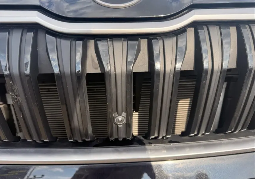 Gros plan sur la calandre noire verticale du Skoda Kodiaq 2024 avec capteur de stationnement intégré.