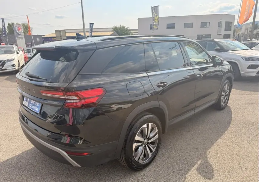 Vue 3/4 arrière droite du Skoda Kodiaq noir 2024 avec feux arrière LED et jantes alliage, stationné en extérieur.
