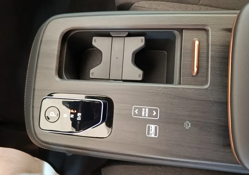 Gros plan sur la console centrale noire du Nissan Ariya 63kWh 218ch Engage avec sélecteur de vitesse et rangement intégré.