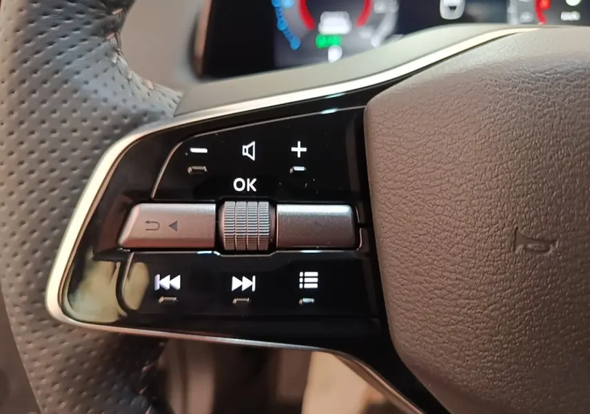 Gros plan sur les commandes multifonctions du volant cuir noir du Nissan Ariya 63kWh 218ch Engage 2026.
