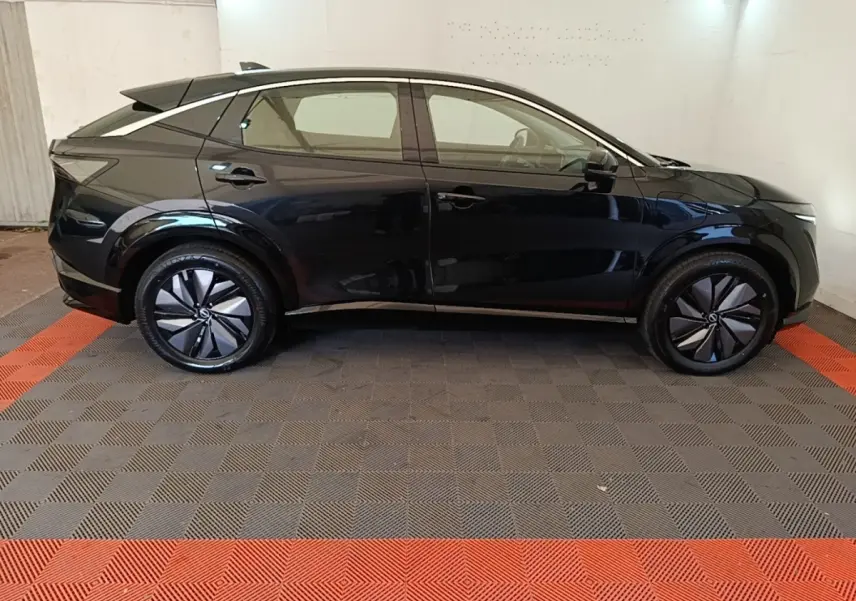 Profil droit du Nissan Ariya noir 63kWh 218ch Engage électrique, avec jantes modernes et lignes fluides.