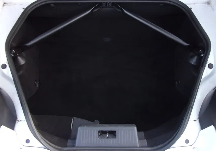 Coffre ouvert vu de dessus du Renault Wind blanc glacier, montrant l’espace de rangement intérieur noir.