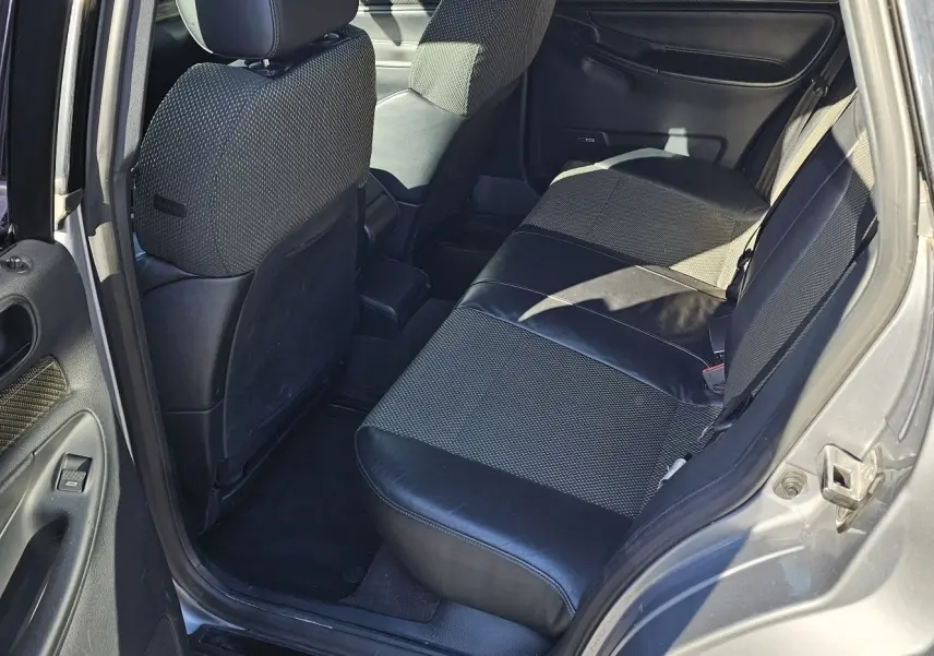 Vue intérieure côté droit arrière de l'Audi RS4 Avant gris, montrant les sièges arrière en cuir noir et tissu.