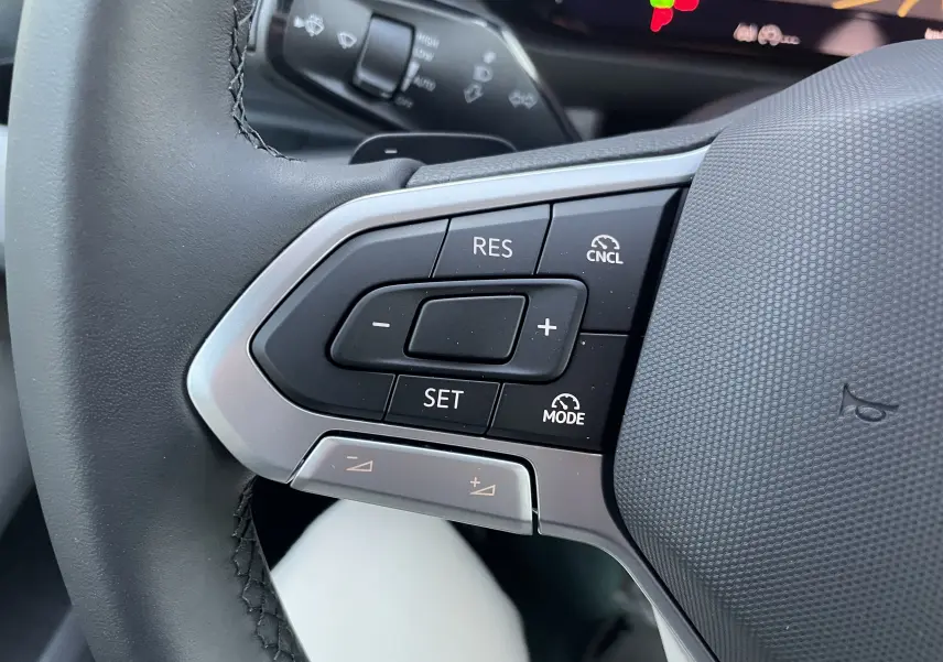 Gros plan sur les commandes de régulateur de vitesse au volant du Volkswagen Crafter Van noir intense 2025.