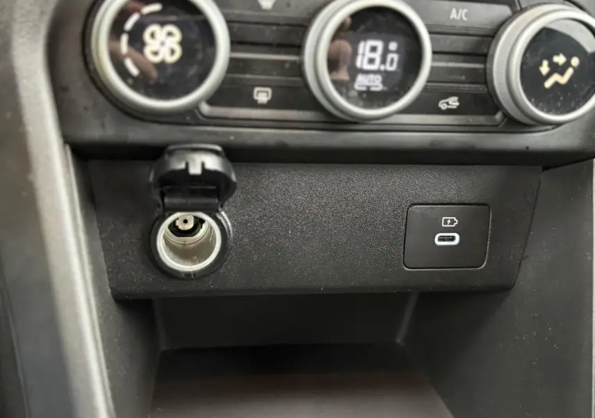 Vue rapprochée de la console centrale du Dacia Jogger 2025, montrant prise allume-cigare et port USB-C.