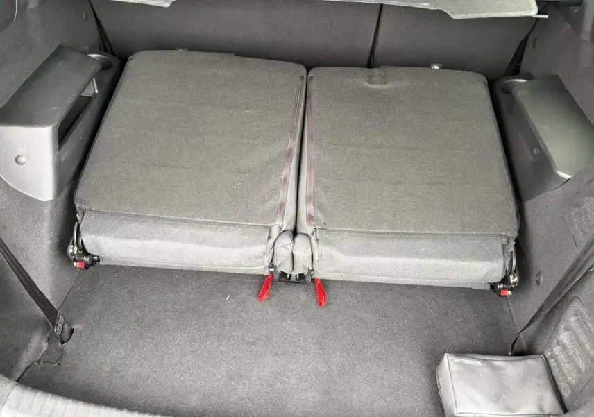Vue du coffre avec sièges arrière rabattus en tissu gris foncé du Dacia Jogger ECO-G 100 Expression 2025.