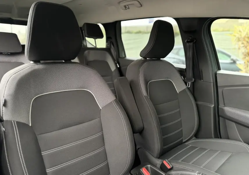 Vue intérieure rapprochée des sièges avant noirs avec surpiqûres blanches du Dacia Jogger 2025, finition Expression.