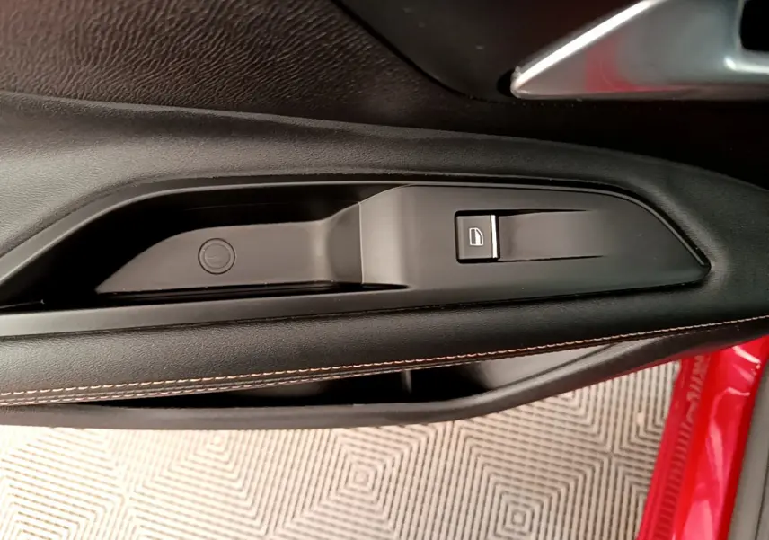 Détail de la commande de verrouillage sur la porte intérieure côté conducteur d’un Peugeot 3008 rouge 2021.