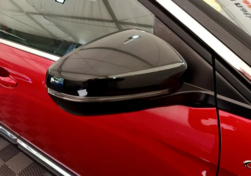 Gros plan sur le rétroviseur noir brillant côté gauche du Peugeot 3008 GT rouge, mettant en valeur la porte et la finition chromée.