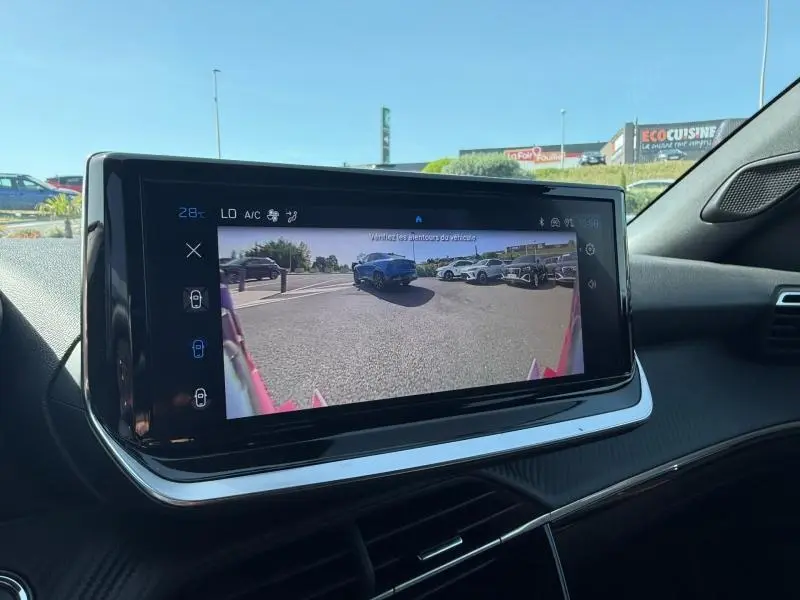 Vue intérieure sur l'écran multimédia affichant la caméra de recul du Peugeot 2008 Rouge Elixir, version hybride 2025.