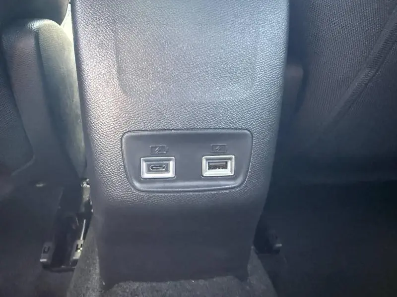 Vue rapprochée des ports USB-C et USB-A situés à l'arrière de la console centrale d'un Peugeot 2008 Rouge Elixir.