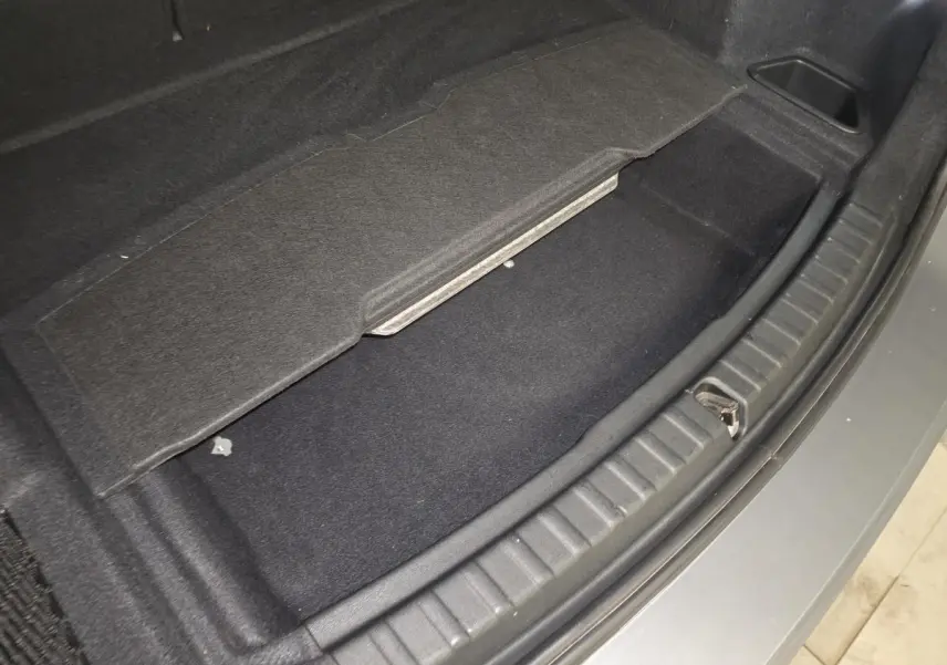 Coffre ouvert en partie avec compartiment de rangement sous plancher, vue arrière, BMW Série 2 gris métallisé.