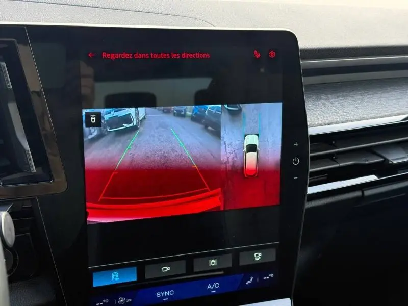 Écran intérieur montrant la caméra de recul et vue 360° du Renault Austral blanc nacré avec toit noir étoilé.