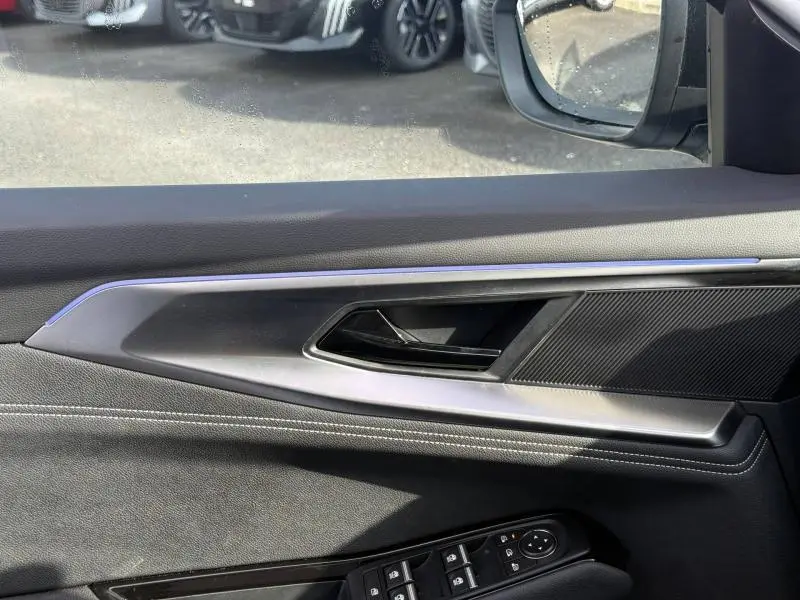 Détail de la porte côté conducteur du Renault Austral 2025 blanc nacré avec garniture noire et commandes électriques.