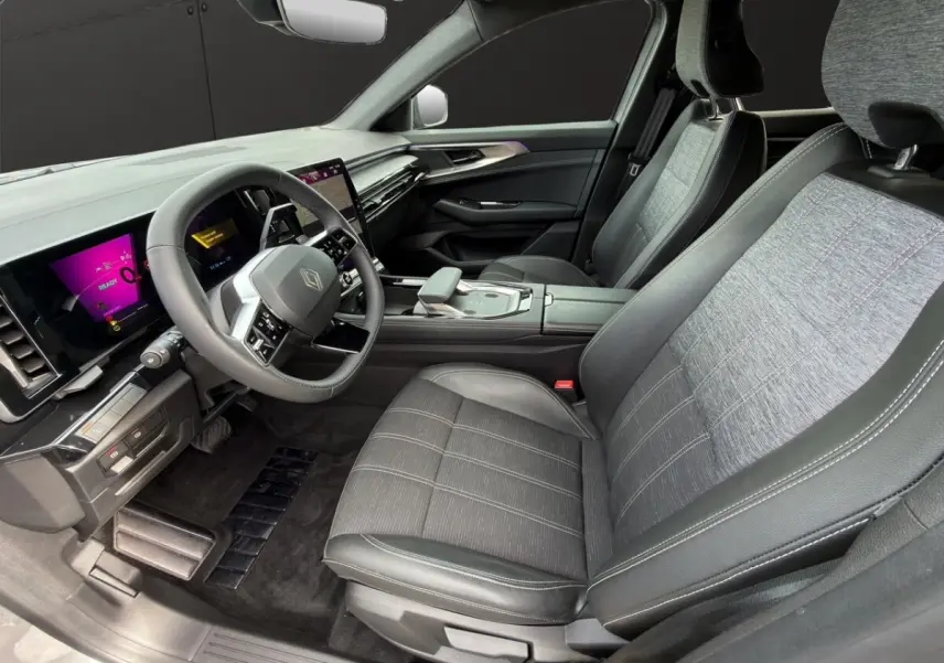 Vue intérieure côté conducteur du Renault Austral gris foncé, avec sièges tissu et cuir, volant multifonctions et écran tactile central.