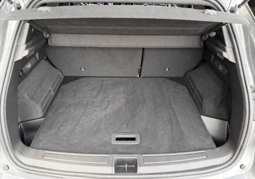 Vue plongeante sur le coffre gris foncé du Renault Austral 2025, avec banquette arrière rabattue et cache-bagages visible.
