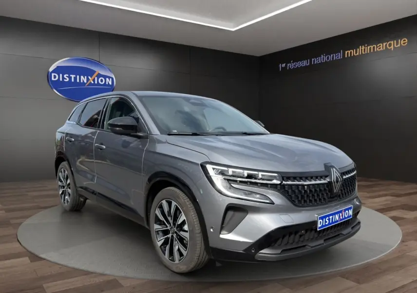 Renault Austral Techno E-Tech gris foncé en 3/4 avant droit, avec calandre noire et jantes alliage distinctives.
