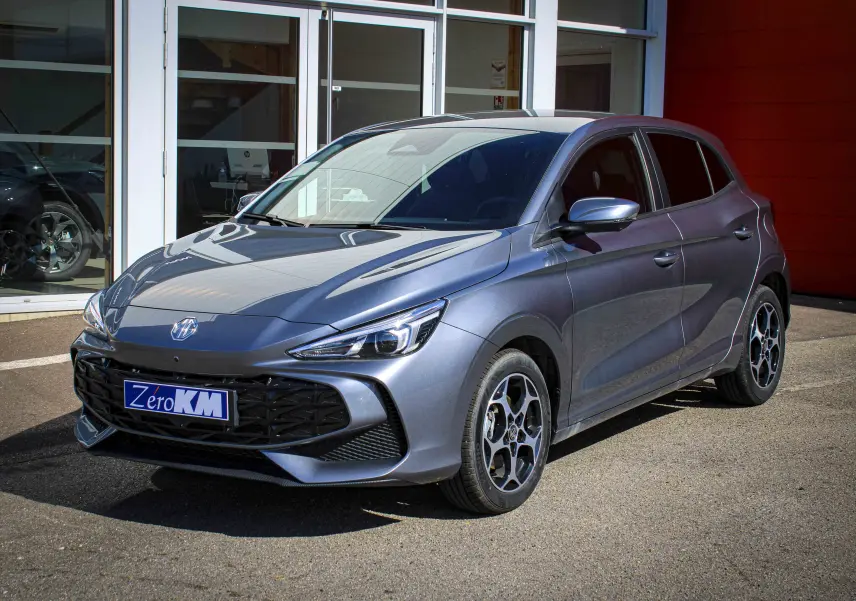 MG3 1.5L Hybrid+ 195ch Luxury en Hampstead Grey, vue 3/4 avant avec jantes distinctives et calandre noire.