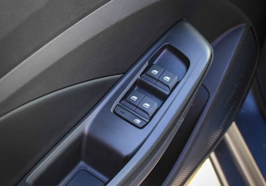 Gros plan sur les commandes des vitres électriques côté conducteur du MG3 2026 en gris Hampstead, intérieur noir.