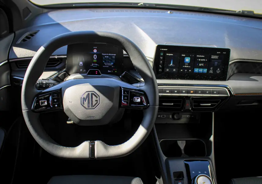 Vue intérieure centrée sur le volant multifonction et l'écran tactile du tableau de bord du MG3 gris.