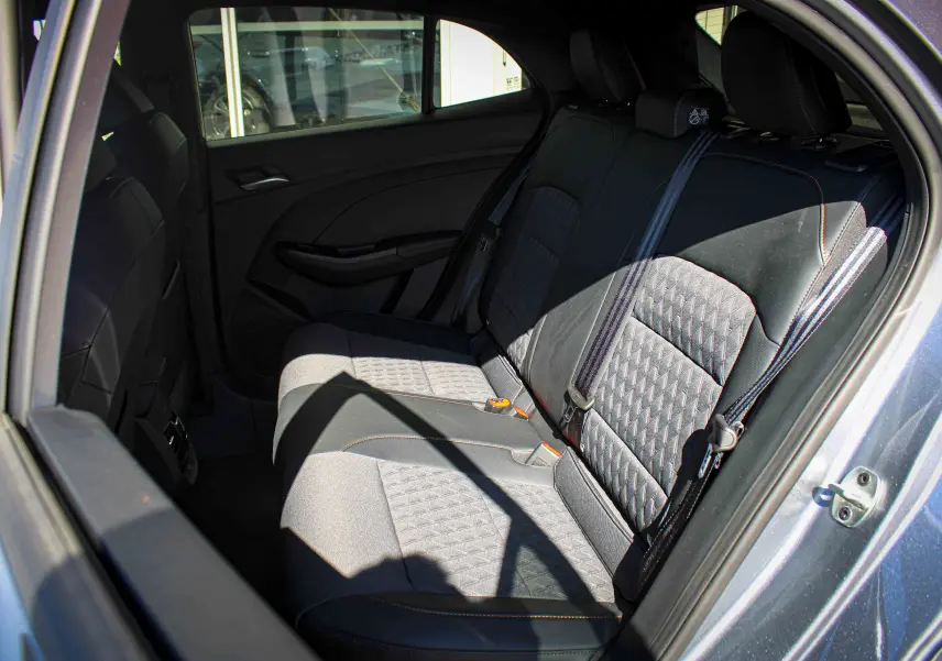 Vue intérieure côté droit des sièges arrière en tissu noir avec surpiqûres orange d'une MG3 1.5L HYBRID+ 195CH LUXURY gris métallisé.