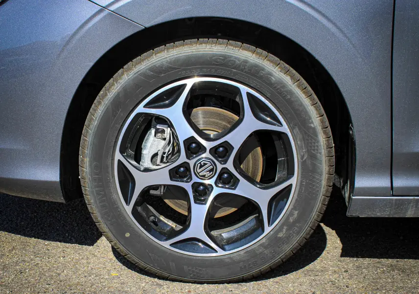 Gros plan sur la roue avant gauche du MG3 1.5L Hybrid+ 195CH Luxury en gris Hampstead avec jante alliage cinq branches.