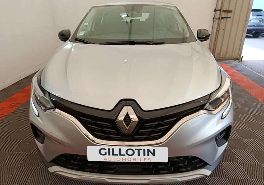 Vue avant du Renault Captur Business E-Tech hybride gris clair, mettant en valeur la calandre noire et les phares LED fins.