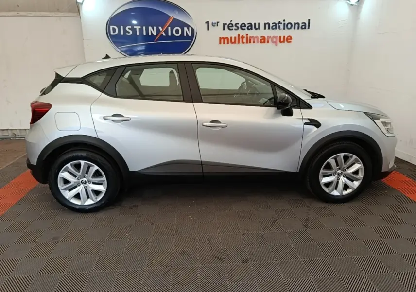 Profil droit d'un Renault Captur Business E-Tech hybride gris clair 2022 avec jantes alliage et protections noires basses.