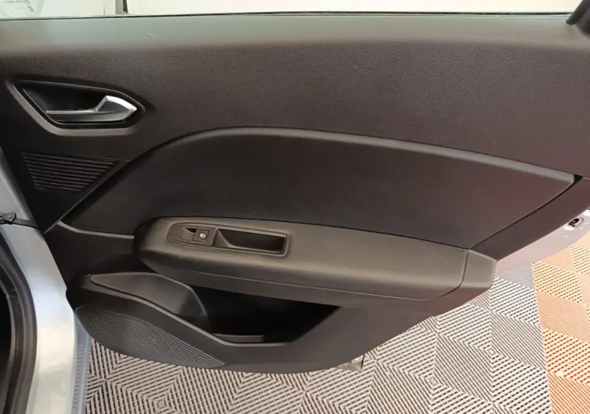 Vue intérieure côté gauche de la porte avant d’un Renault Captur Business E-Tech hybride gris clair avec commande de fenêtre.