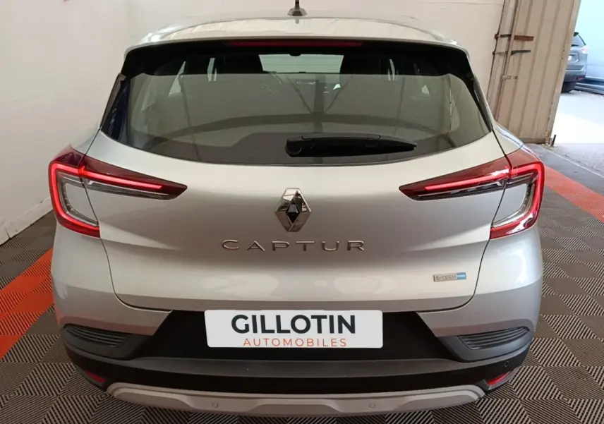 Vue arrière d’un Renault Captur Business E-Tech hybride gris clair 2022 avec feux LED et logo central visible.