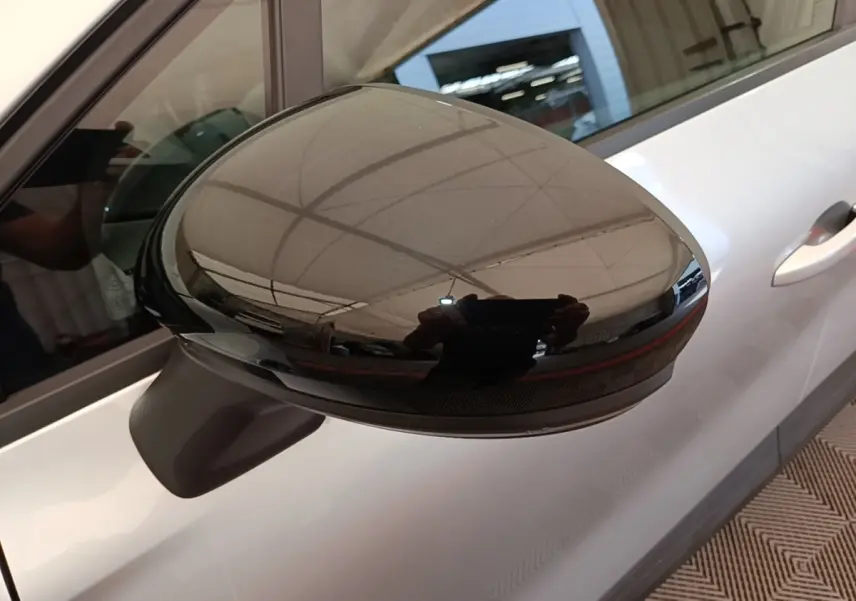 Gros plan sur le rétroviseur noir brillant côté gauche du Renault Captur Business E-Tech gris clair, vue latérale partielle.