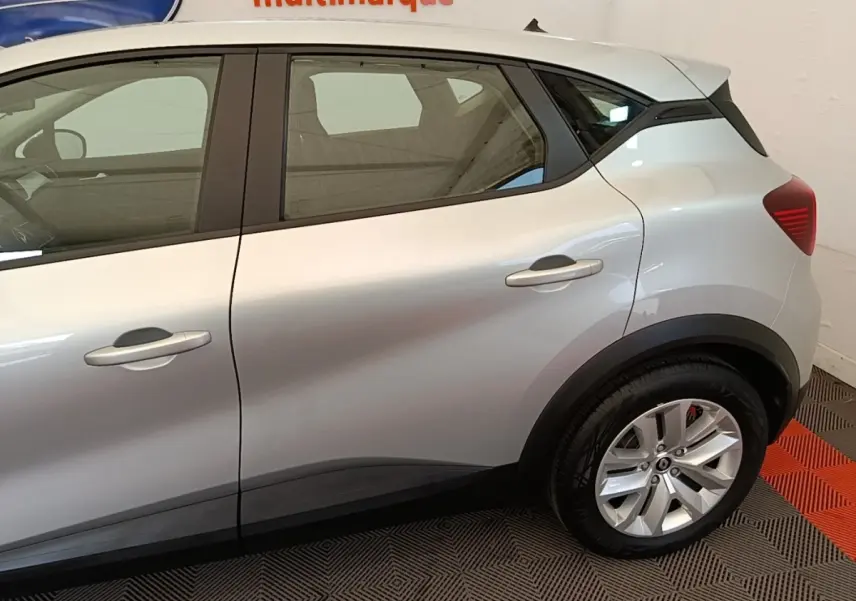 Vue latérale droite du Renault Captur Business E-Tech hybride gris clair, mettant en valeur les lignes de caisse et la roue arrière.