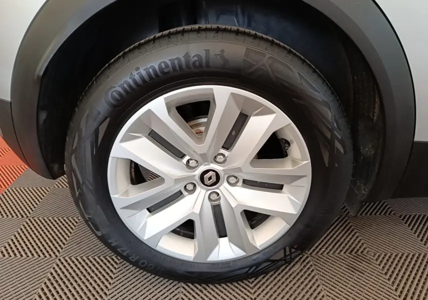Gros plan sur la roue avant droite du Renault Captur gris clair, mettant en valeur la jante alliage et le pneu Continental.